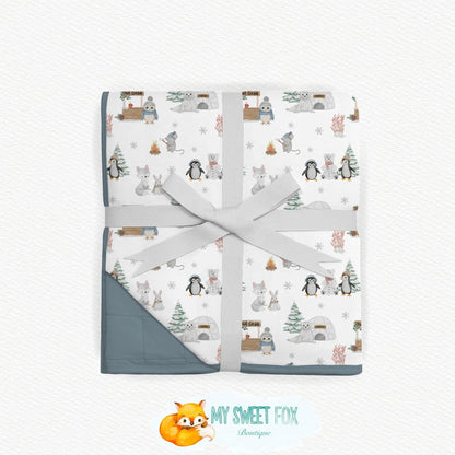 Arctic animal bamboo blanket wrapped in a light gray ribbon and tied with a bow, displayed on a textured white background. The bottom corner of the blanket is turned over to show a solid gray backing.