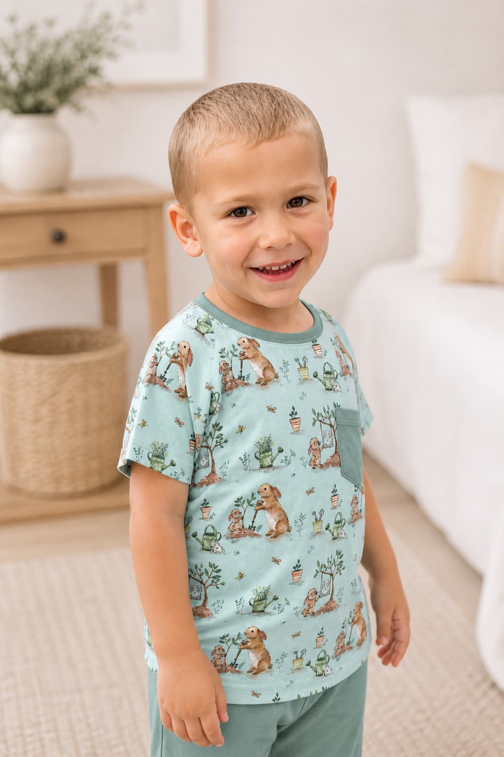 Child wearing a light blue bamboo t-shirt with bunny prints in a living room setting