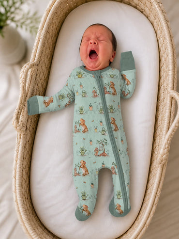 Newborn baby in a  bunny patterned bamboo pajamas sleeper yawning in a woven basket.