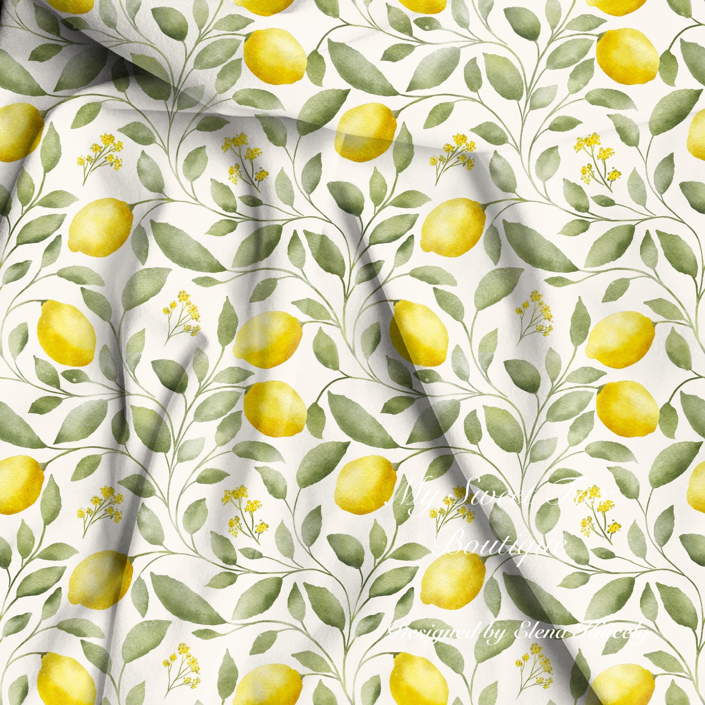 Watercolor lemon and leaf patterned bamboo viscose fabric with yellow lemons, green leaves, and small yellow flowers on a white background, shown with soft folds.