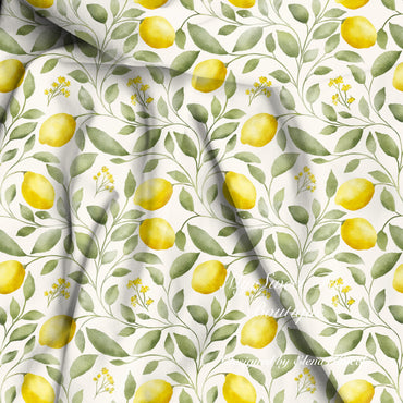Watercolor lemon and leaf patterned bamboo viscose fabric with yellow lemons, green leaves, and small yellow flowers on a white background, shown with soft folds.